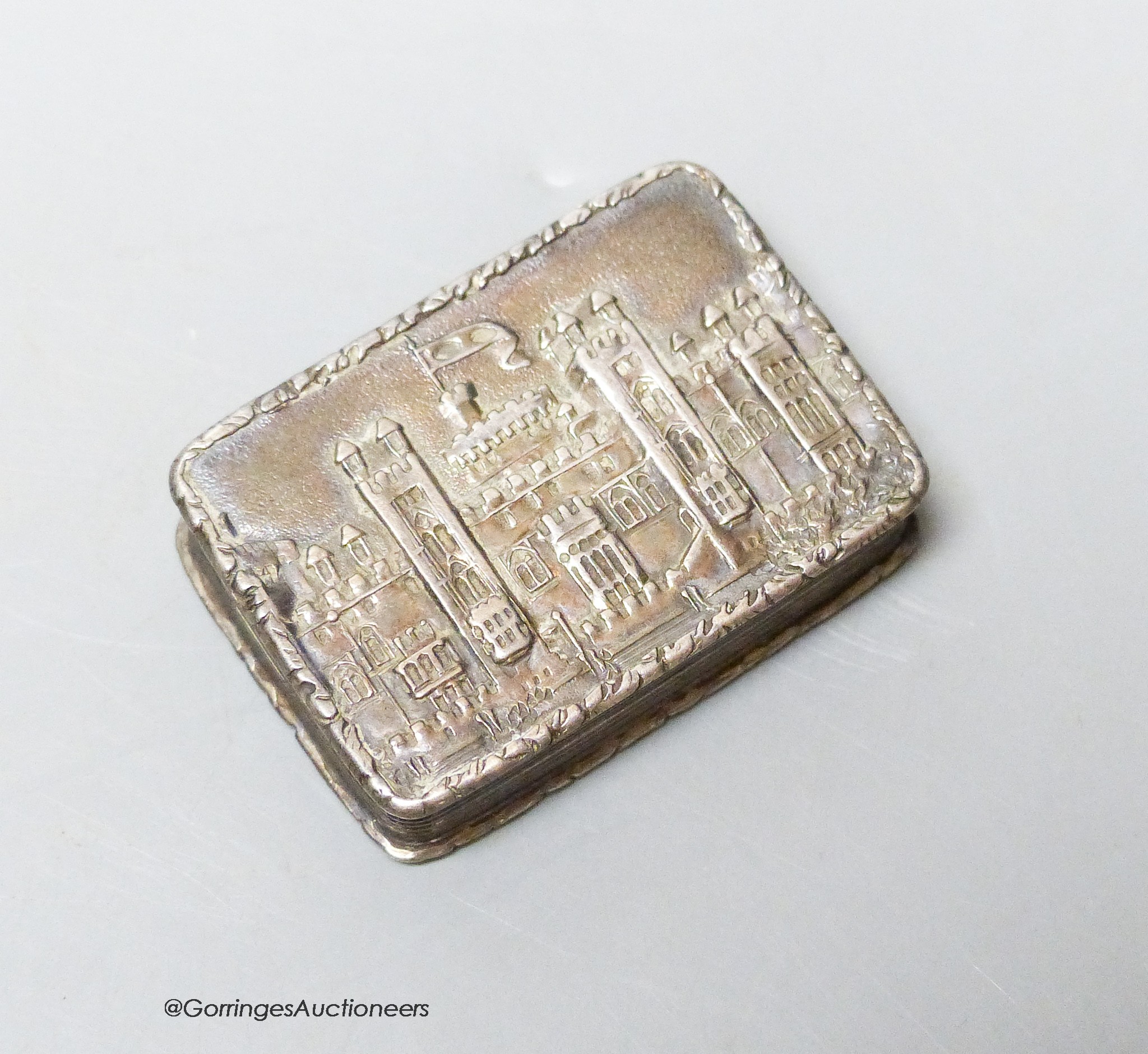 An early Victorian silver rectangular castle top vinaigrette, by Nathaniel Mills, Birmingham, 1839, (lid detached), 36mm, 24mm.